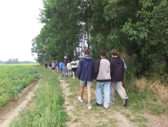 Leerlingen stappen op een veldweg richting het Kraterbos.