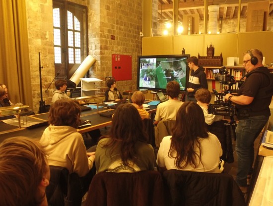 Een groep leerlingen kijkt naar de presentatie van een medeleerling.